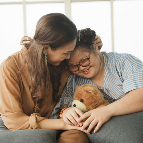 NDIS Nominee supporting down syndrome daughter to learn and relax from the internet, embracing child to encourage down syndrome girl at home